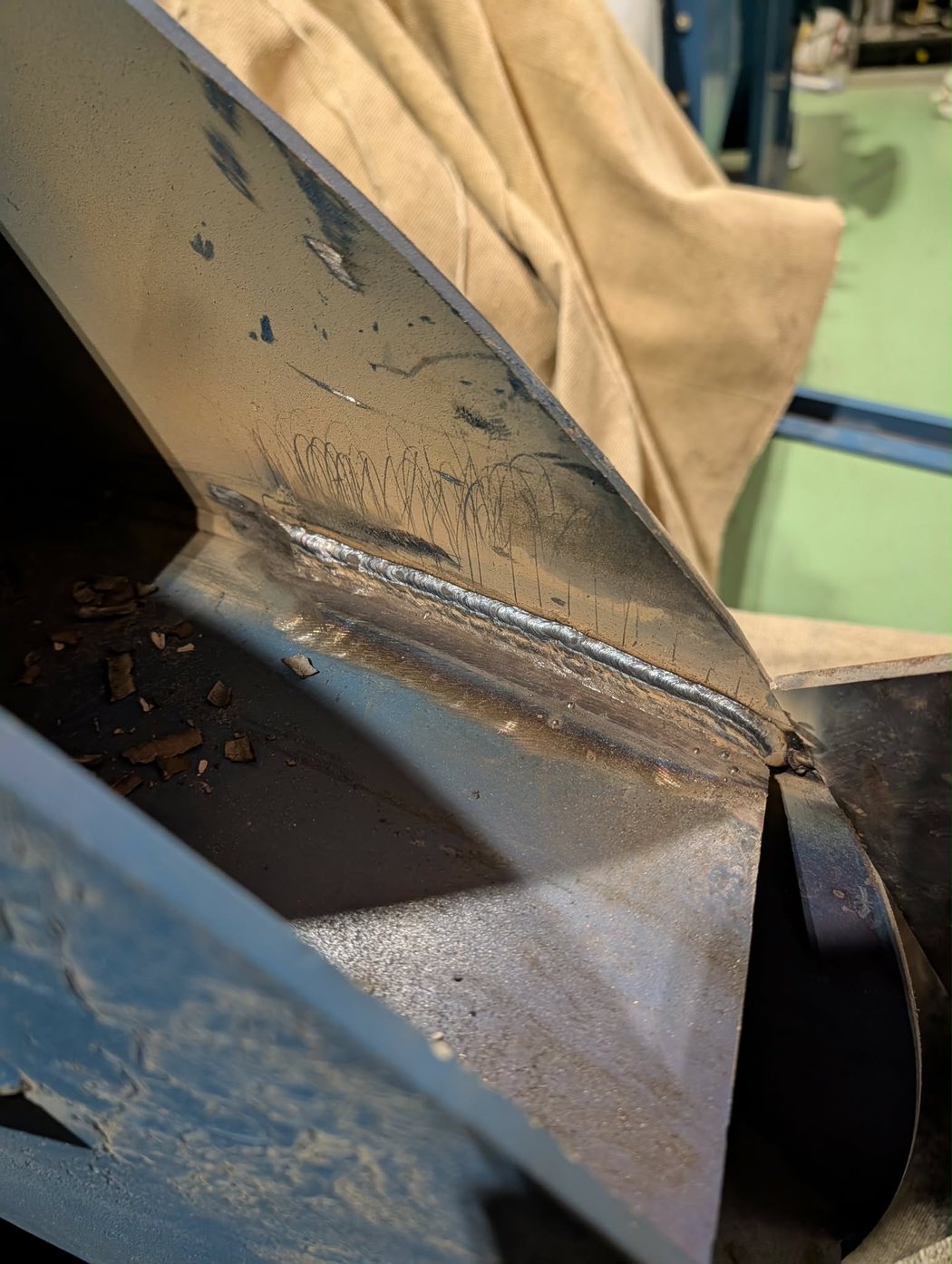 Gros plan d'un cordon de soudure d'angle réalisé par Soudure MobilX sur une pièce d'acier industrielle